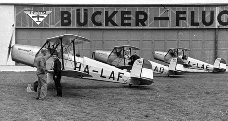 18.kép

A LÜH részére gyártott, magyar jelzésekkel ellátott Bücker Bü131A-k a Rangsdorfi Bücker repülőgépgyár udvarán 1937-ben (Forrás: https://www.rbb-online.de)
 
 
