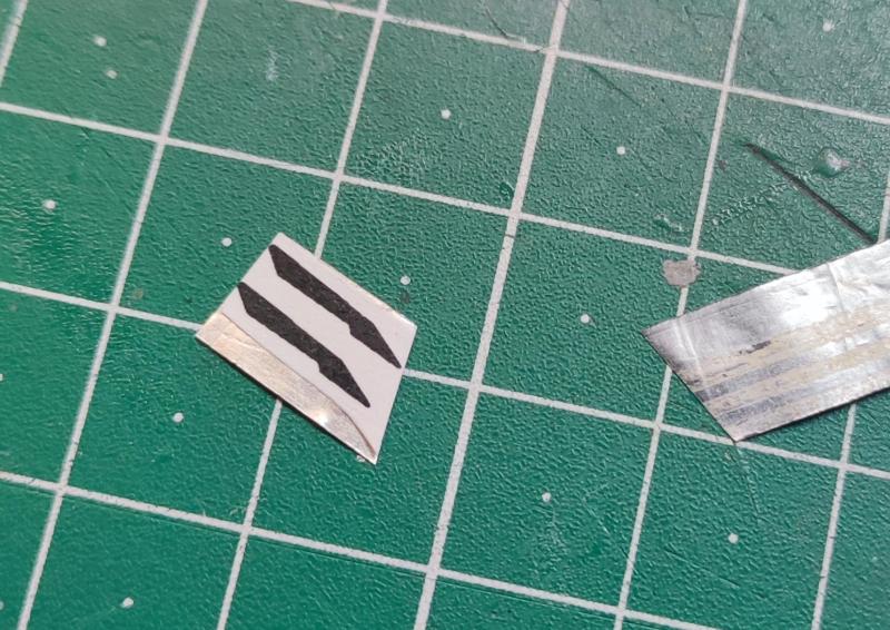 A Quinta Studio matricája alapján megtervezett erősítések a függőleges vezérsíkokra

Jobbra a szikepenge vékony fémfóliája, balra a kinyomtatott és papírragasztóval a fóliára rögzített cucc.