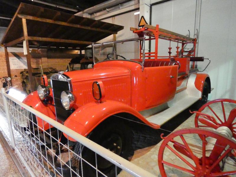 A tűzoltóautó élénk színfolt a sok sötétzöld acél között