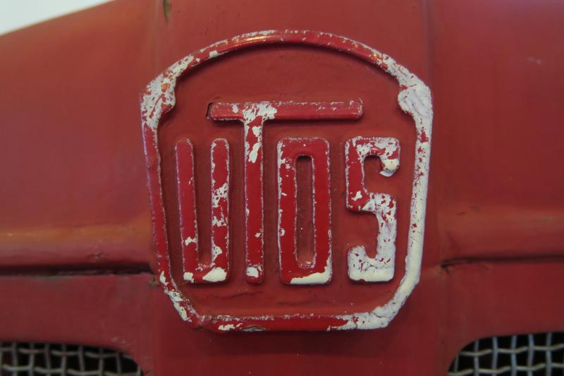 UTOS logó

A román IAR repülőgépgyárat a háború után a szovjetek leszerelték, a gépeket elszállították. Ezután traktorok gyártásával foglalkozott.
A rövidítés a Sztálinvárosi Traktorgyárra, azaz Uzina Tractorul Orașul Stalinra utal. 1960 után ez lett az UTB, azaz Brassói Traktorgyár.

Romániában Brassó volt az az iparváros, aminek fel kellett vennie a diktátor nevét. 1950 és '60 között viselte azt, sőt a város fölé magasodó Cenk hegy oldalában is megjelenítették fenyőfákkal. A desztálinizáció idején végül inkább körbeültették ezeket, így tűnt el a felirat, pedig ma is ott van az erdőben.